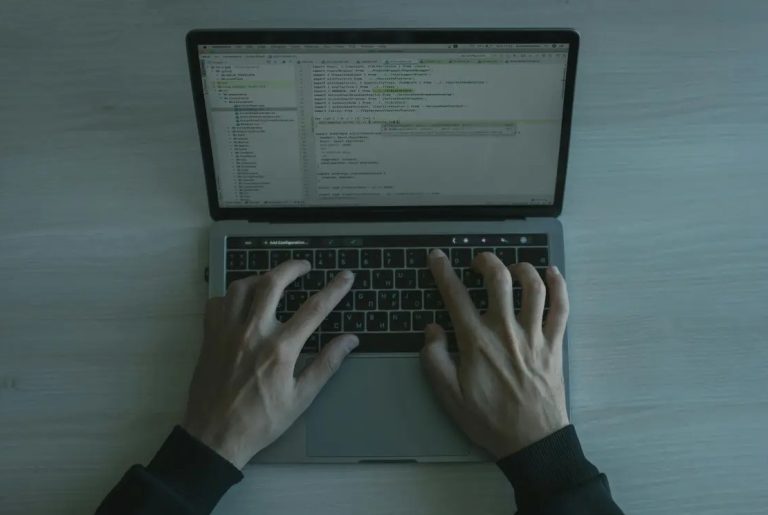 man typing on laptop keyboard